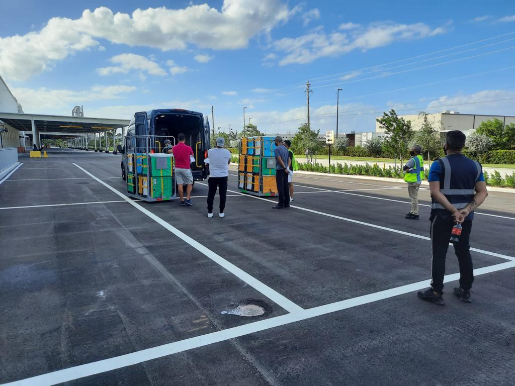 Equipo de BOOZ cargando paquetes en las camionetas de reparto en la estación