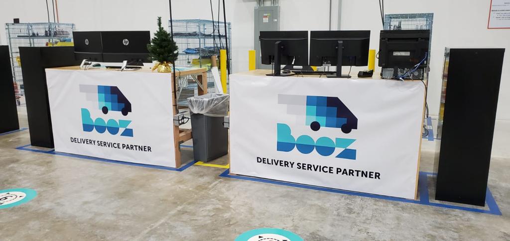 Mesas de la oficina de BOOZ con el logo de la empresa en la estación